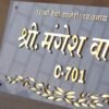 3D Devanagari nameplate with embossed lettering, crafted from a white and gold acrylic sheet.