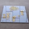 White and golden acrylic Arabic calligraphy name plate in a rectangular shape, measuring 12x8 inches with name, room number, and elegant Arabic calligraphy.
