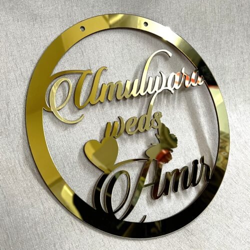 Golden round wall hanging with couple's name. Acrylic and MDF.