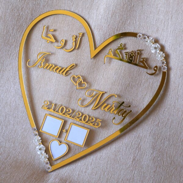 1740235490106 personalized wedding thumb board in heart-shaped design with floral embellishments, this nikah thumb board is made using golden and transparent acrylic sheets. It is used as a wedding keepsake that can be showcased on a cabinet.