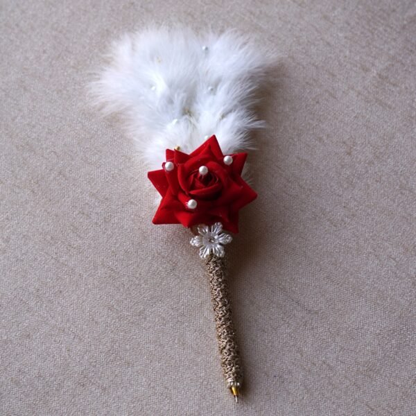 DSC07685 “Close-up of a decorative Nikah signing pen featuring a glittery lace-wrapped barrel, a red artificial rose with pearl-studded floral accents, and white feather plumes.”
