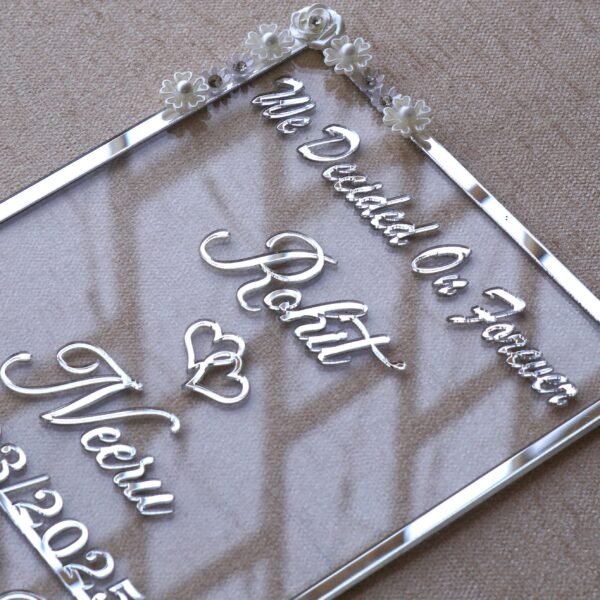 1741871520206 Transparent & silver acrylic personalized wedding thumbprint frame with floral corner embellishments, embossed bride and groom names and date, plus dedicated thumbprint spaces.