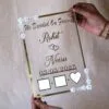 Transparent & silver acrylic personalized wedding thumbprint frame with floral corner embellishments, embossed bride and groom names and date, plus dedicated thumbprint spaces.